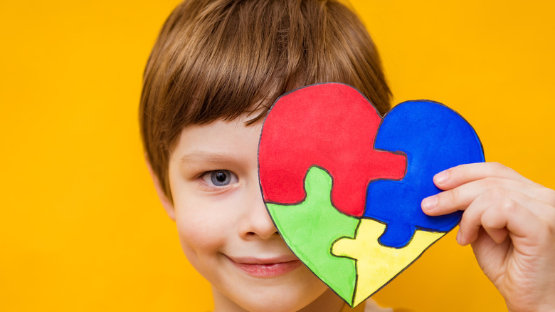 boy holding puzzle heart