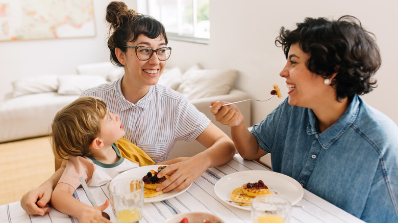 Kid eating breakfast with parents