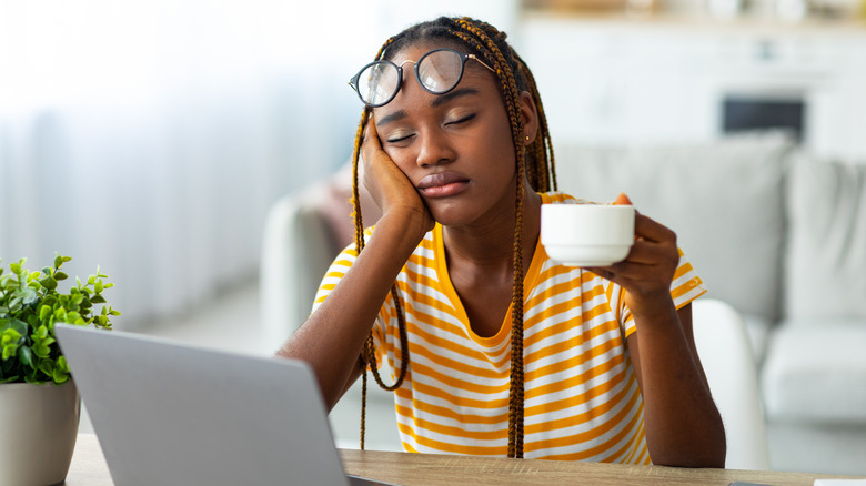 woman asleep with a cup of coffee