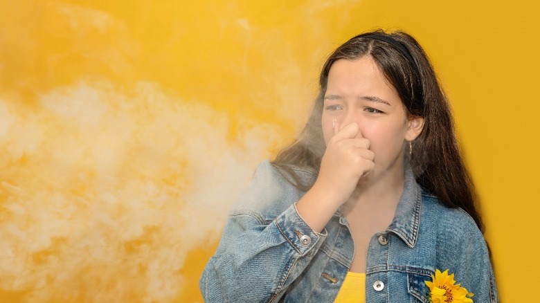 Woman covering nose because of smoke