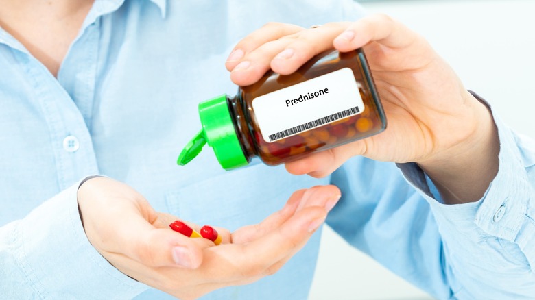 Person pouring prednisone pills into their hand