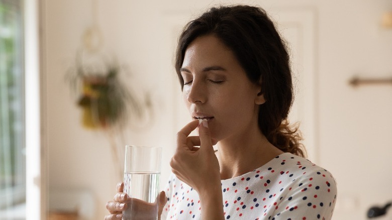 woman taking migraine medication