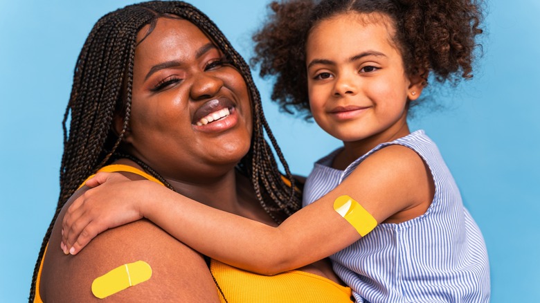mother and daughter with band-aids on upper arm