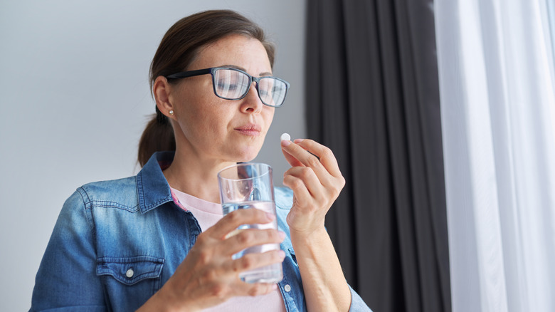woman holding pill with water