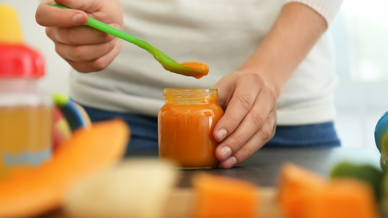 Hands making homemade baby food