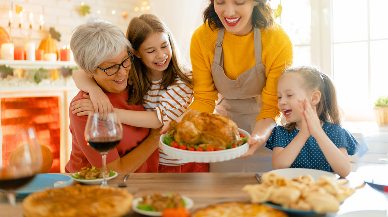 Woman giving turkey to family