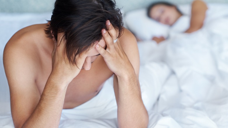 man with headache in bed