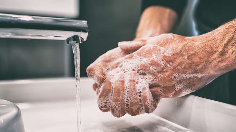 Hand washing and masked woman in airport