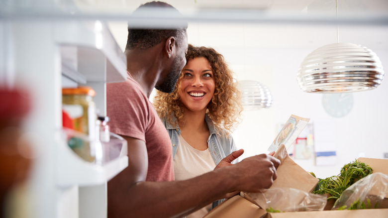 couple unpacking food in a kitchen