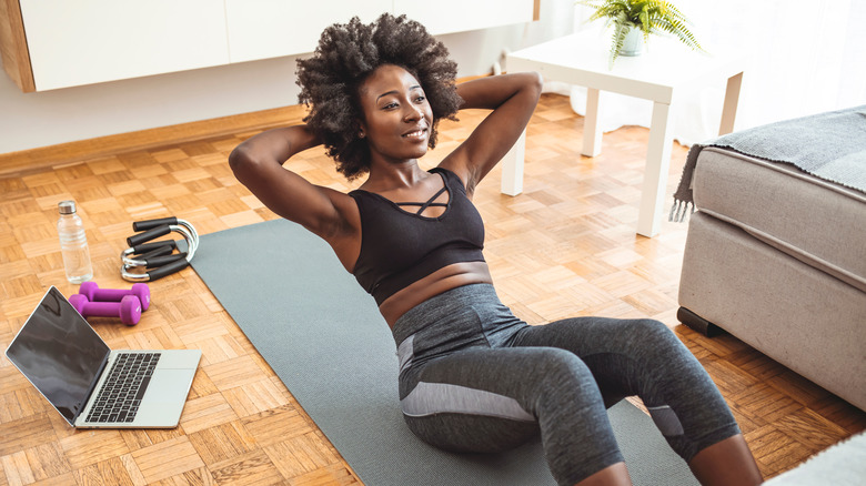 Black woman exercising in living room