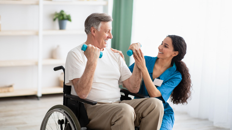 man in wheelchair using dumbbells