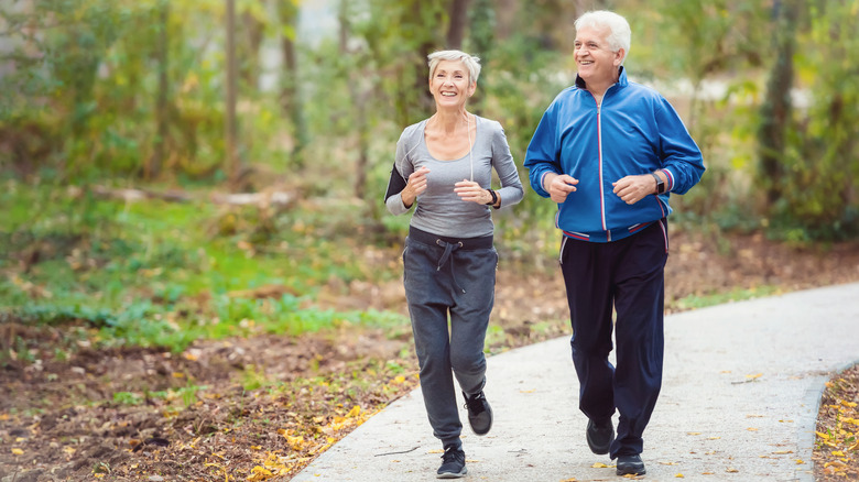 Smiling older couple jogging outdoors