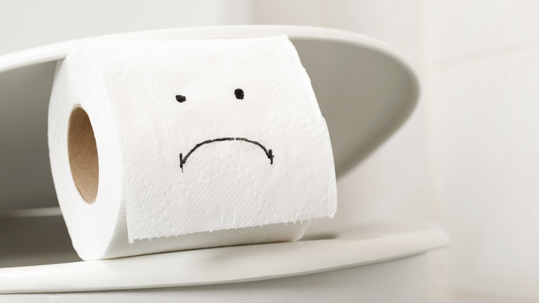 toilet roll with frowny face