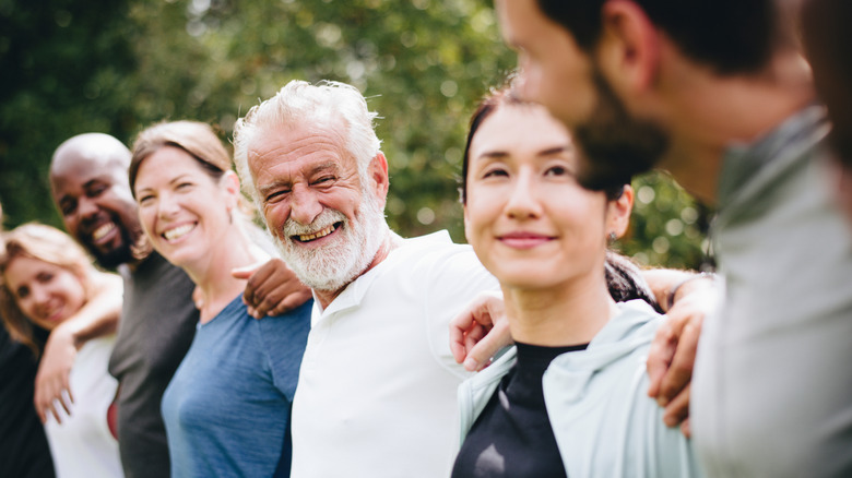 Group of people with arms around each other's shoulders