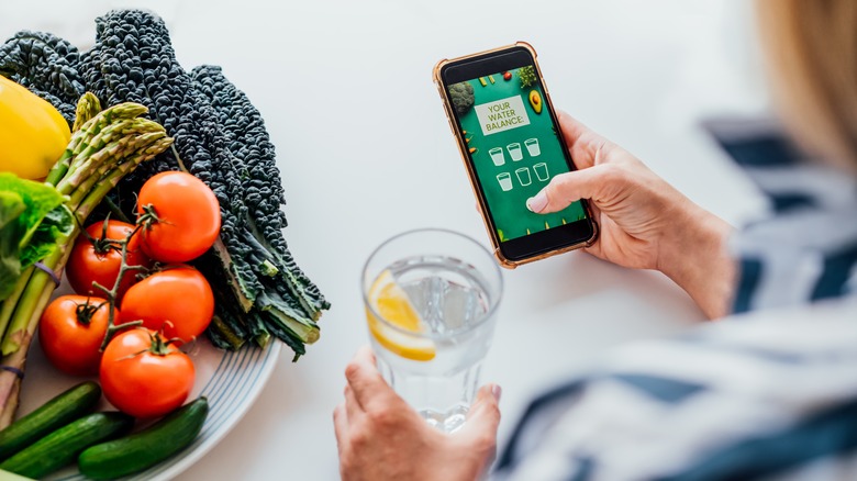 Person tracking water intake with app