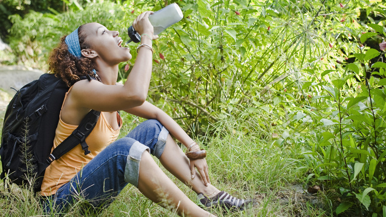 Woman drinking from water bottle on hike