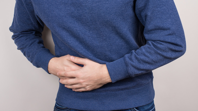 Man with bladder pain holding abdomen