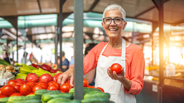 Woman holding tomato in market