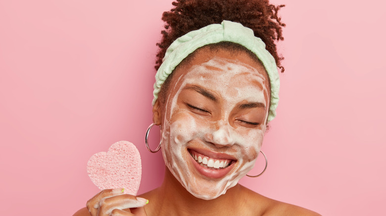 a woman washing her face and treating her acne 