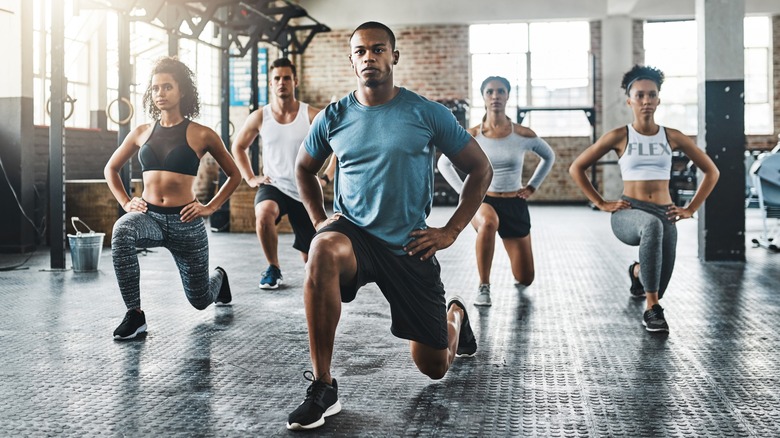 several fit people doing a lunge during a workout class