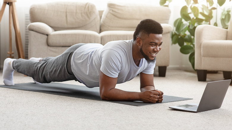 man doing a forearm plank in his living room