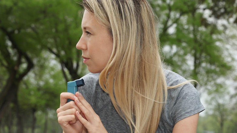 woman holding asthma inhaler