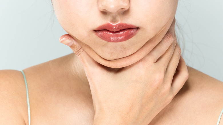 woman double chin with hand at throat 