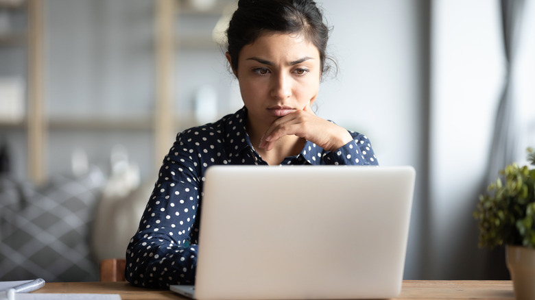 Woman staring intently at laptop screen