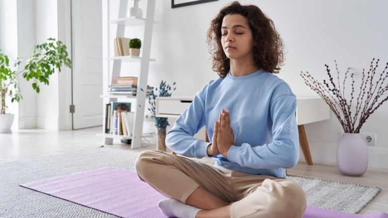 woman reduces stress through meditation