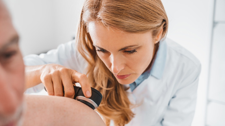 dermatologist examining man's skin