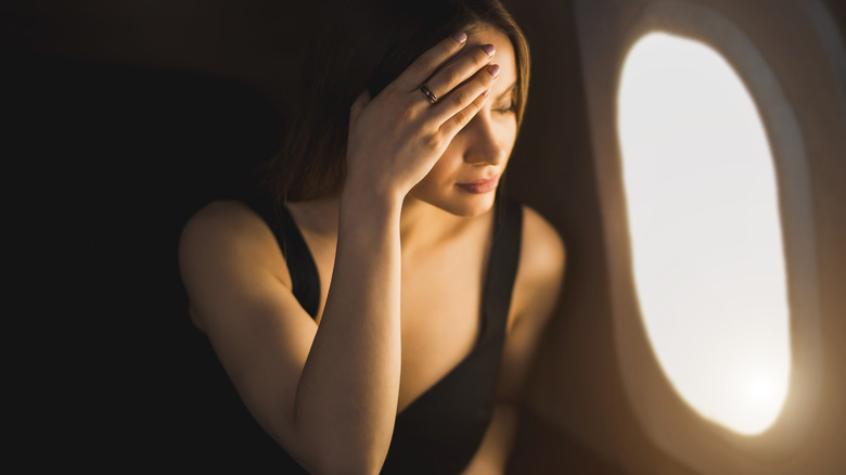 woman plane headache migraine