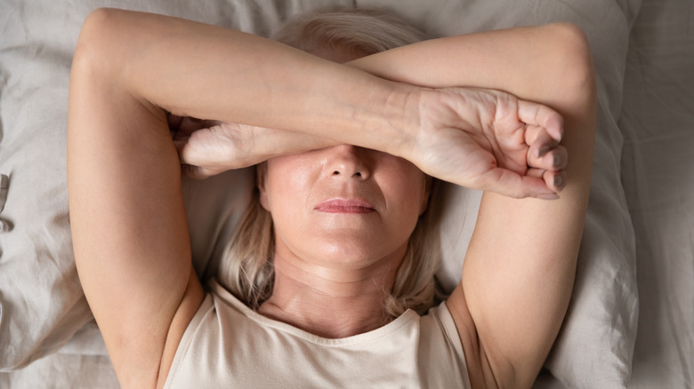 woman headache lying bed