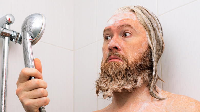 Man washing beard in shower