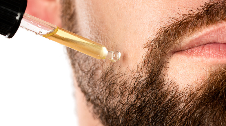 Man applying beard oil with dropper