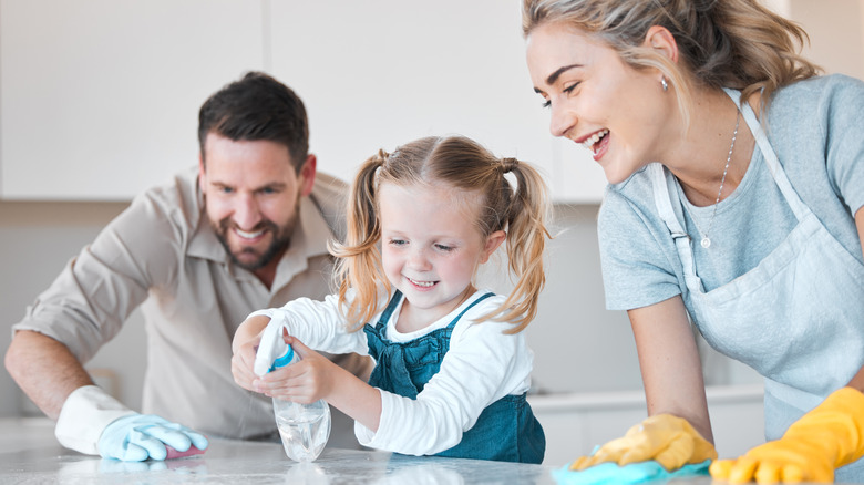 Smiling family cleaning countertops