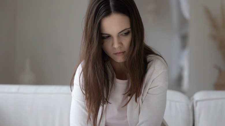 woman sitting on a couch looking upset