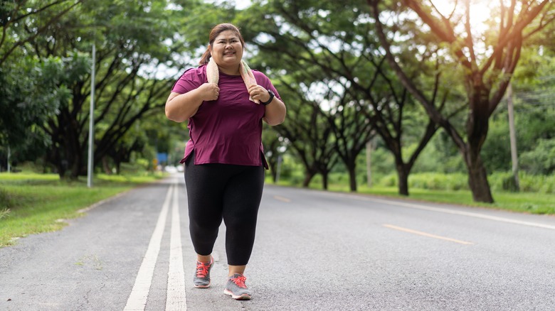 Overweight woman jogging in a park