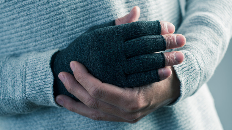 Man in sweater wearing compression glove