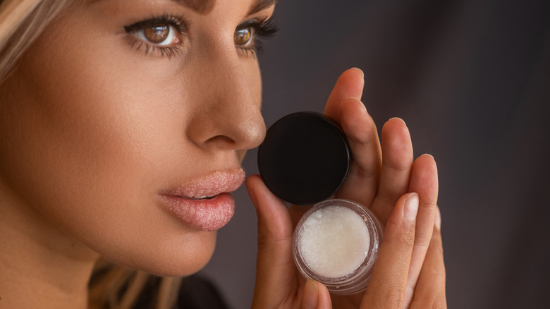 woman holding open lip scrub