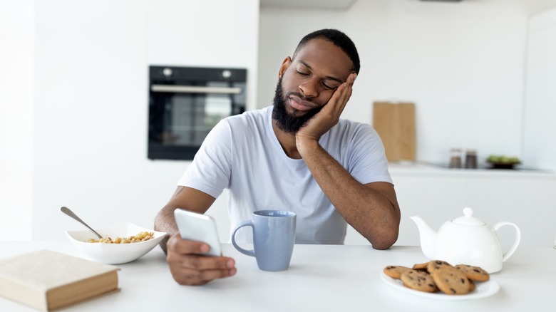 Sleepy man sitting in kitchen