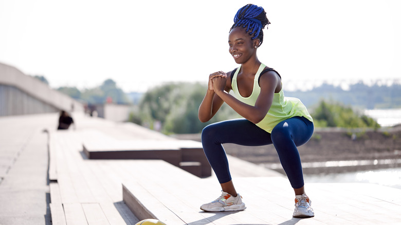 woman doing air squats outside