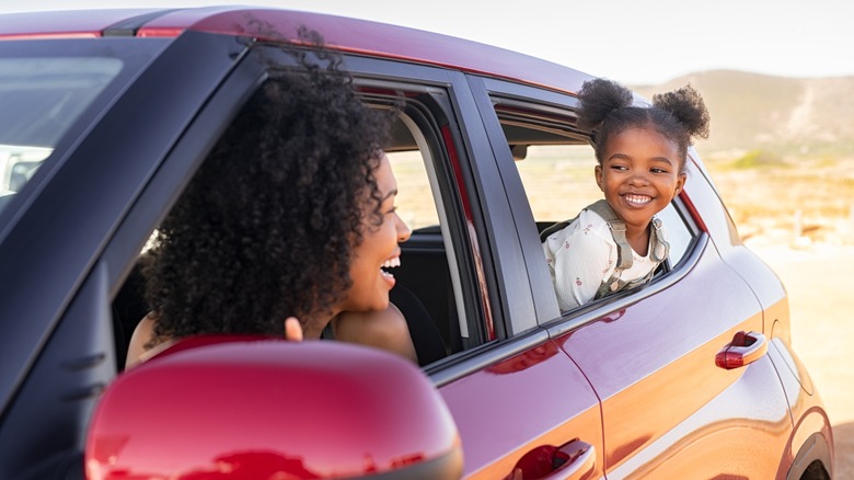 mom and daughter laughing on a road trip