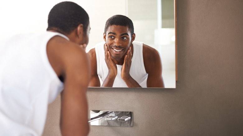 a young man cleaning his face