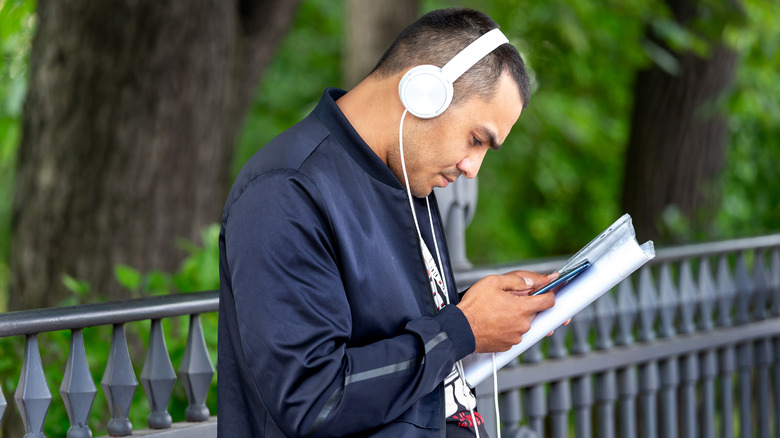 man wearing headphones looking at phone