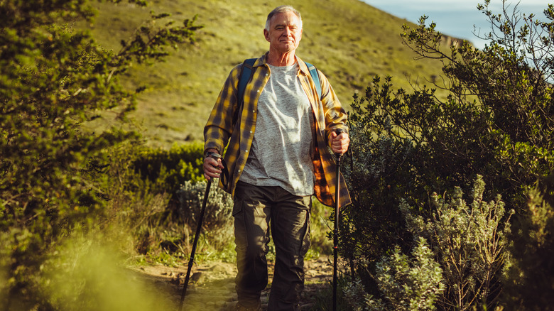 man walking with trekking poles