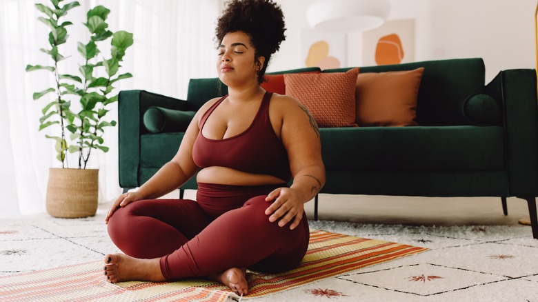 woman meditating on floor at home