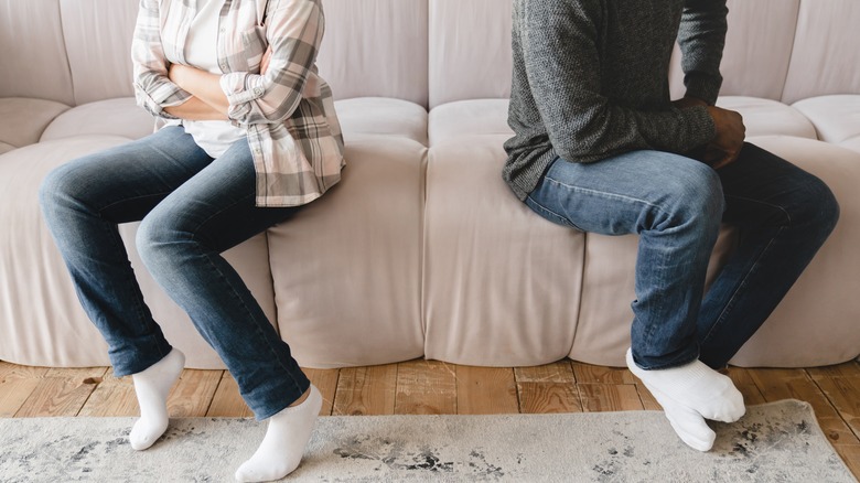 man and woman arguing on couch