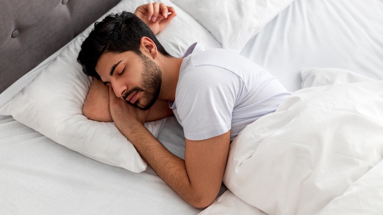 man comfortably sleeping in bed