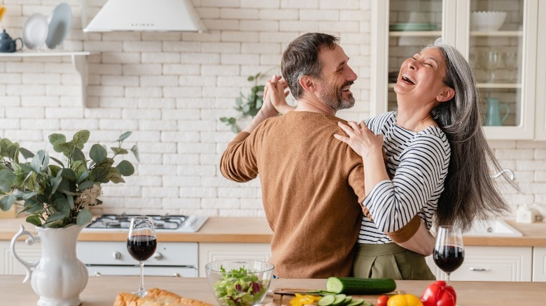 couple dancing while preparing meal