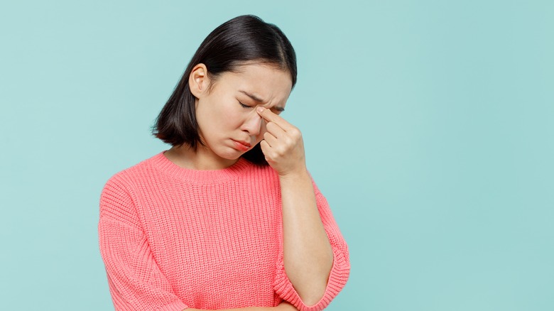 Woman holding bridge of nose